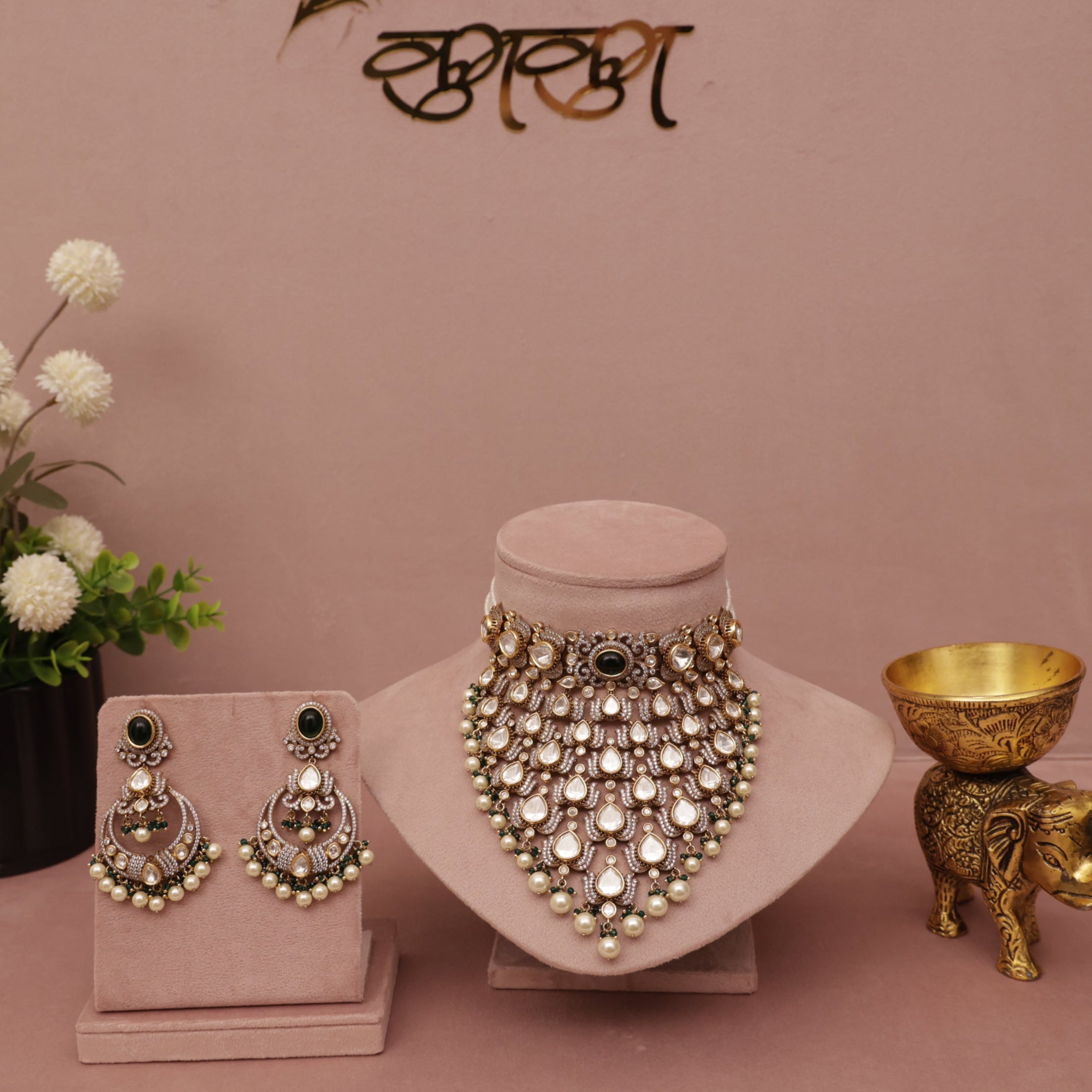 Jewelry set including necklace, earrings, and decorative items on a pink background with 'kumkum' branding.