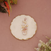 Decorative brooch on a round white stone with floral elements on a pink background