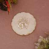 Decorative brooch with floral design on a pink surface with floral elements.