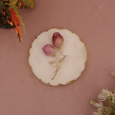 Gold brooch with pink flowers