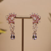A pair of gold-toned floral drop earrings with pink and clear rhinestones, designer earring for a perfect fastival